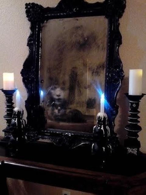 a haunted mirror in a black frame, with a ghost, is a cool and bold idea for Halloween decor