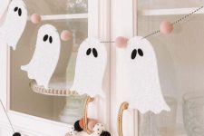 a little and cute ghost banner with pink felt pieces and colorful felt balls are great to style your space for Halloween