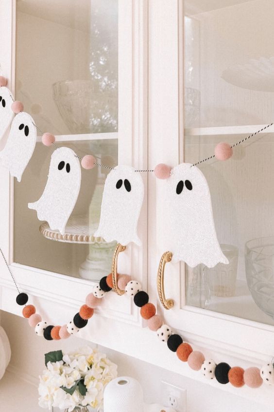 a little and cute ghost banner with pink felt pieces and colorful felt balls are great to style your space for Halloween