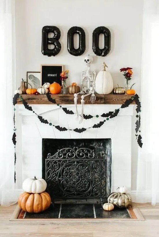 a lovely Halloween fireplace with stacked pumpkins, black bat buntings, pumpkins and a skeleton on the mantel and black balloon letters