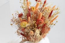 a lovely dried flower arrangement of blooms and grasses in a mug is a cool idea that you can easily realize