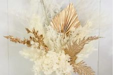 a lovely dried flower centerpiece of gilded leaves, fronds, bunny tails, white blooms and white grasses is a gorgeous idea