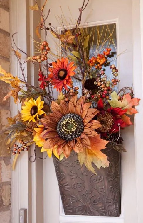 a lovely fall faux flower arrangement with leaves, berries and twigs in traditional fall colors will substitute a usual wreath