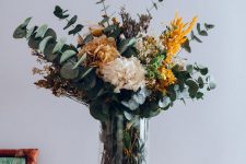 a lovely fall flower arrangement of eucalyptus, dried grasses and some faux flowers is a lovely idea