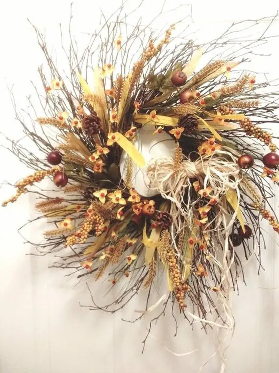 a lush twig fall wreath with faux flowers, fruits, pinecones, ribbons, feathers, wheat and hay and many other elements