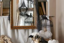 a mirror in a vintage gilded frame with a ghost sticker and a black cheesecloth piece is great for Halloween