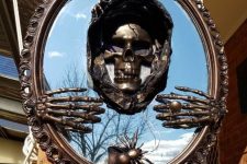 a mirror in an elegant vintage frame, with a skull and skeleton hands plus a spider can be DIYed