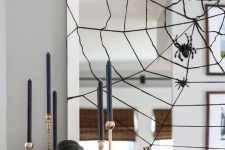 a mirror with a black spiderweb and spiders plus a small faux blackbird is a cool decor idea for Halloween