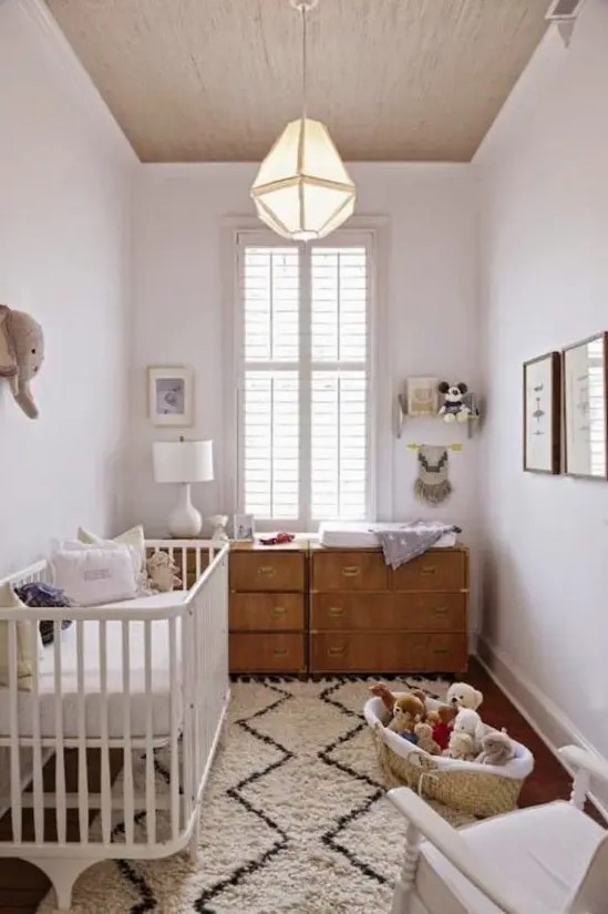 a neutral mid-century modern nursery with a stained dresser, a white crib, a printed rug and some toys in baskets is a cool idea