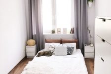 a neutral narrow bedroom with a bed, matchign nightstands, a fluffy rug, a pendant lamp and a dresser