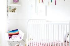 a neutral nursery spruced up with bold colors, with modern white furniture, colorful textiles and toys is a pretty and lovely kid’s space