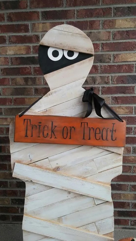 a plywood mummy is a very long-lasting decoration that you can easily make, add a sign and a crate with sweets and candies