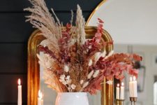 a pretty colorful dried flower arrangement with bold leaves, grasses and flowers is a cool idea for a fall space