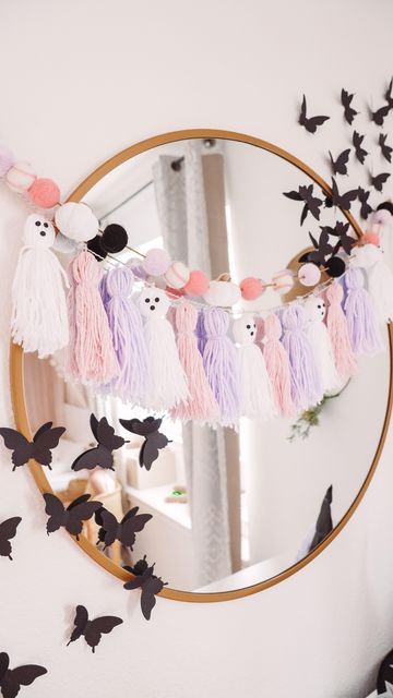 a pretty pastel ghost tassel garland and a pompom one are cute and lovely solutions for Halloween decor