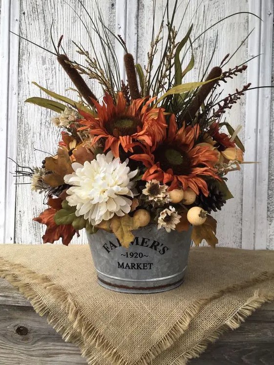 a rustic fall arrangement of rust and white faux blooms, berries, grasses, leaves and other stuff looks very cozy
