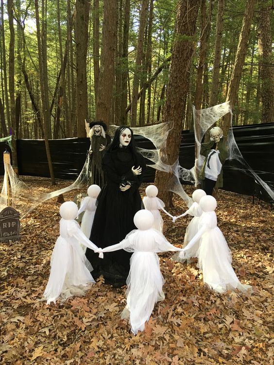 a scary Halloween scene with ghosts, a witch and a skeleton and a graveyard in the yard