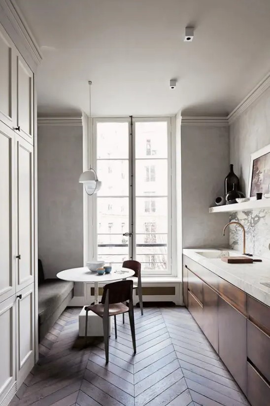 a serene narrow kitchen with metal cabinets and a stone slab countertops, a marble backsplash, a sofa, a table and chairs