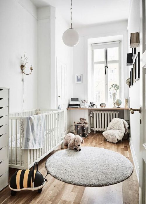 a small Scandinavian nursery with a white crib, a gallery wall, a windowsill with decor, toys and a dresser