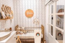 a small boho nursery with accent walls, a metal crib, a white dresser, bookshelves, some furniture and lvoely boho decor