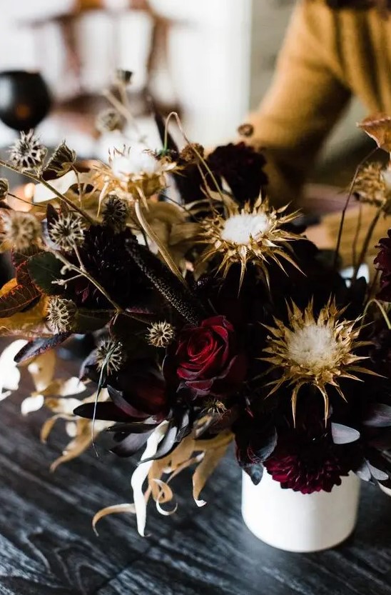 a statement Halloween floral arrangement with deep burgundy roses, dried blooms and leaves looks wow