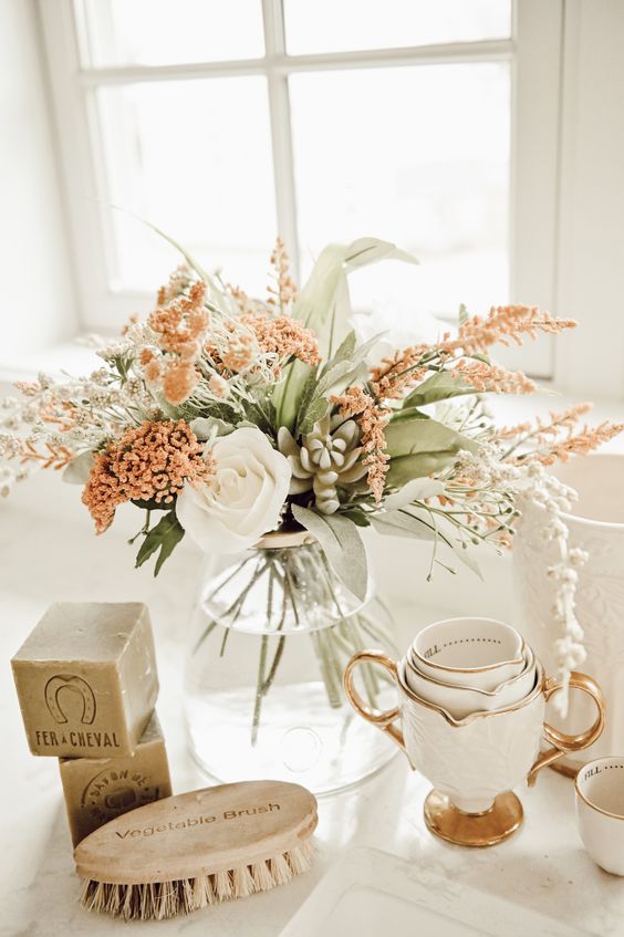 a stylish faux flower arrangement in rust and white plus some faux leaves is a lovely idea for fall decor
