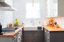 a stylish mid-century modern kitchen with grey lower cabinets and upper white ones, butcherblock countertops and white subway tiles