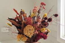 a sumptuous dried flower arrangement done in pink, fuchsia, yellow and burgundy is amazing for the fall