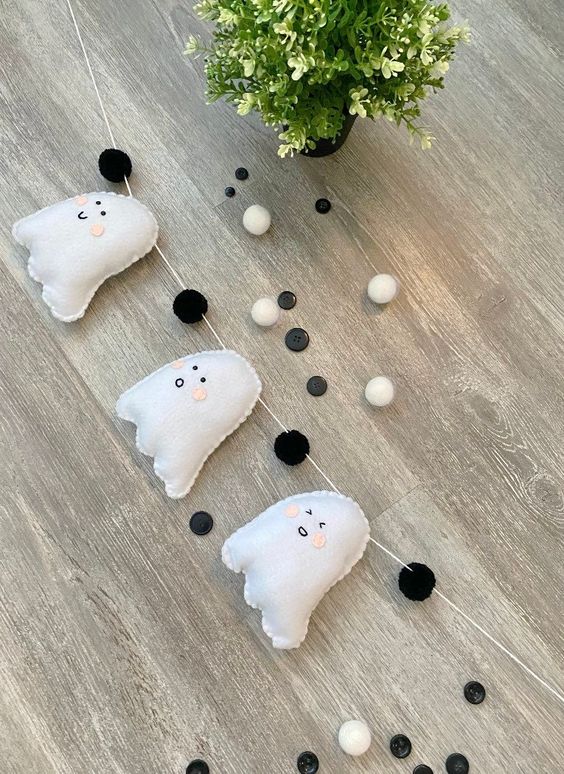 a super cute Halloween bunting of ghosts and black and white pompoms is a lovely decor idea to go for