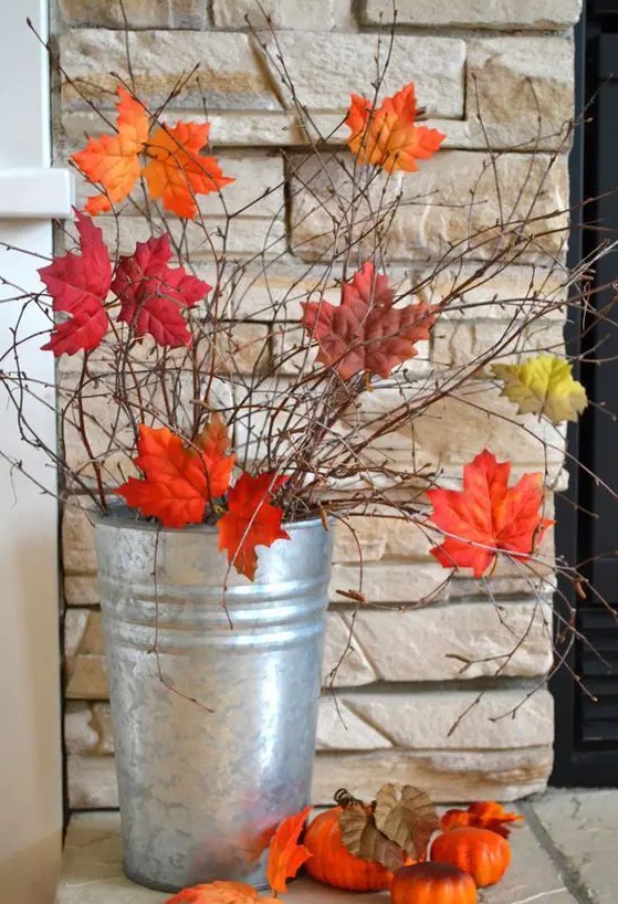 a tin bucket with twigs and branches and with bright fall leaves is a gorgeous and very easy fall decoration