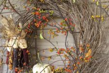 a twig fall wreath with berries, corn cobs and a pumpkin is a lovely idea for home decor in the fall