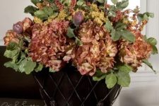 a vintage urn with faux greenery and dried blooms is a refined and chic centerpiece for the fall