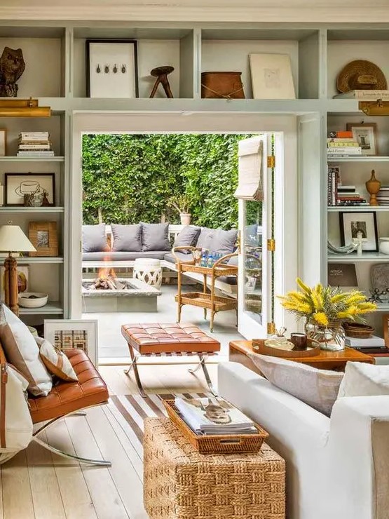 a welcoming neutral living room with open shelves over the doorway for displaying things, books and other stuff is a cool idea to save some space
