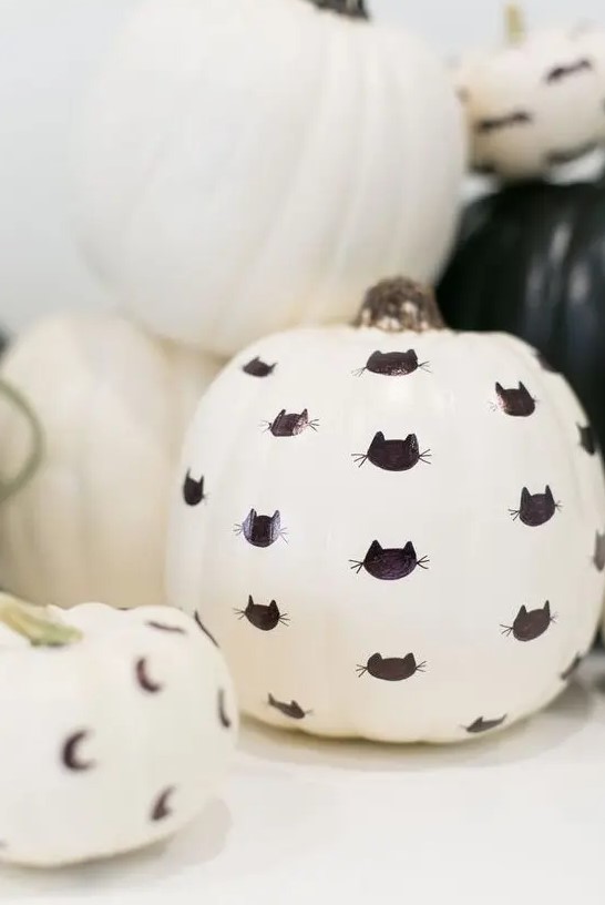 a white faux pumpkin decorated with a black sharpie   with black cats is a simple and lovely idea for Halloween