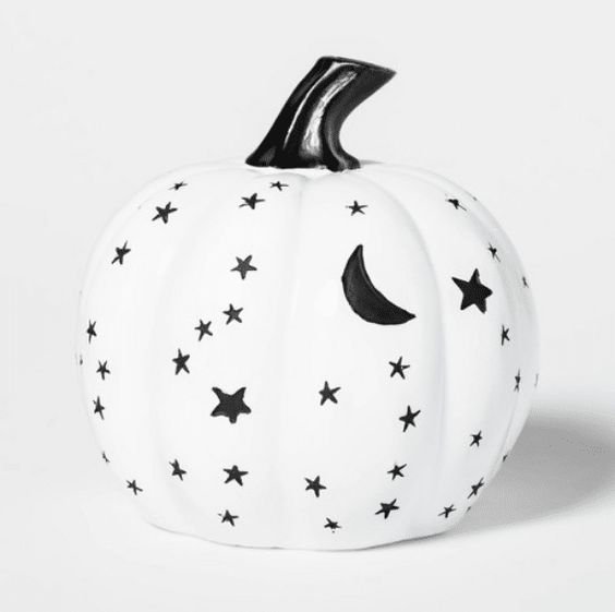 a white pumpkin decorated with a black sharpie in Halloween celestial style