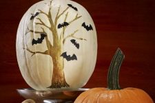 a white pumpkin with a tree and bats drawn with sharpies is a cool Halloween decor idea