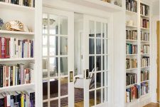 a whole wall taken by lots of open bookshelves on the sides and over the door, with a glass French door is a cool idea to store books and do that with style