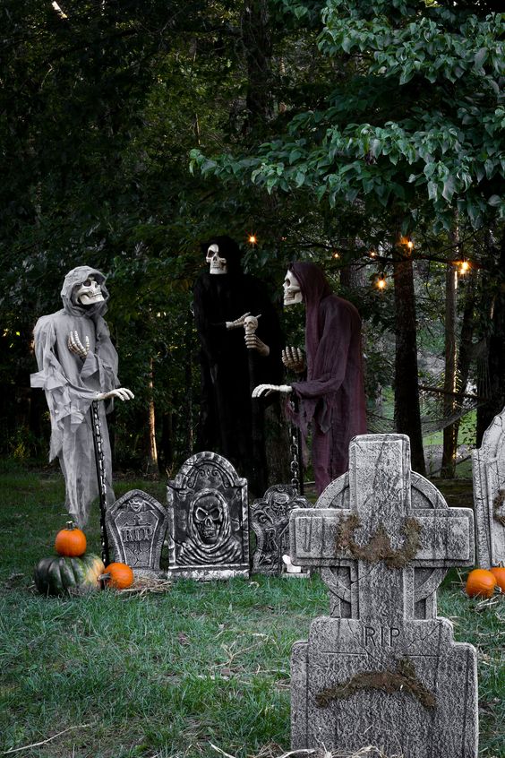 a yard as a graveyard with tombstones, skeletons, pumpkins and lights is a cool Halloween space