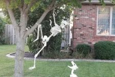 a yard skeleton scene with a skeleton climbing the tree and a skeleton dog is a cool solution for Halloween