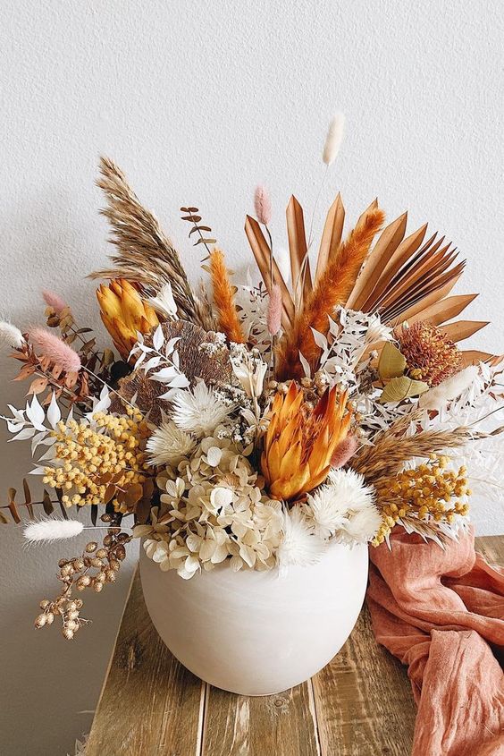 an amazing dried flower arrangement with neutral and rust blooms, leaves and grasses with plenty of texture and dimension