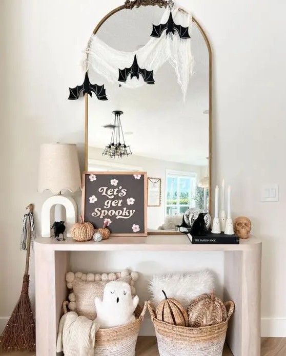 an arched mirror with cheesecloth and paper bats is a simple and cool solution for Halloween