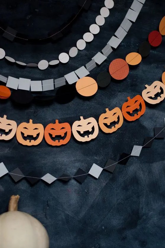 an arrangement of Hallwoeen paper garlands with rhombs, polka dots, squares and jack-o-lanterns