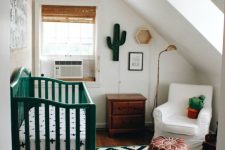 an attic small nursery with a printed rug, a green crib, a white chair, stained furniture, decor, a black pendant lamp