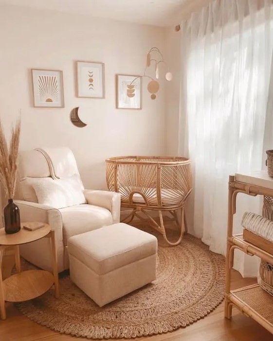 an organic tiny nursery with a rattan bassinet, a white chair with a footrest, a dresser, a side table and a neutral gallery wall