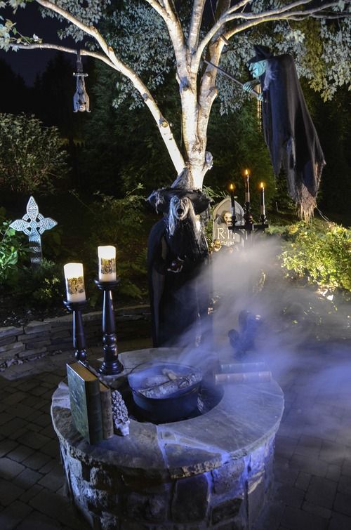 an outdoor Halloween scene with scary witches, a fire pit with a cauldron, candles and lights is amazing for a yard