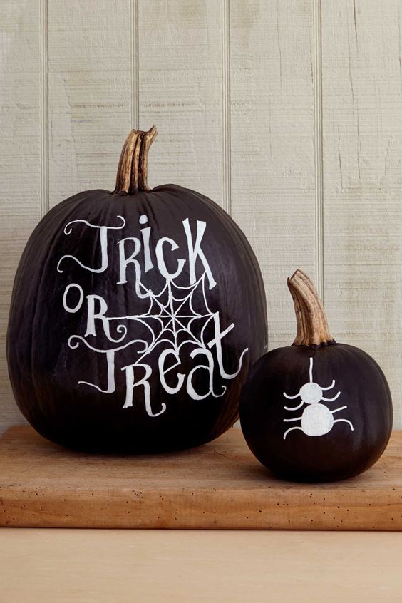 black Halloween pumpkins decorated with white sharpies, with words and a spdier are amazing for decor