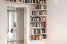 bookshelves covering one wall next to the doorway and a space over it will give you much space for books and will help you declutter the space