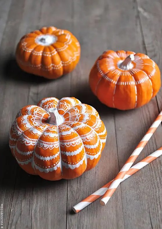 classic orange pumpkins decorated with a white sharpie with some lace patterns look very chic, nice and fun and can be easily DIYed