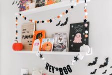 colorful felt pompoms and stars, a banner with stars, ghosts and letters are amazing to style your space for Halloween