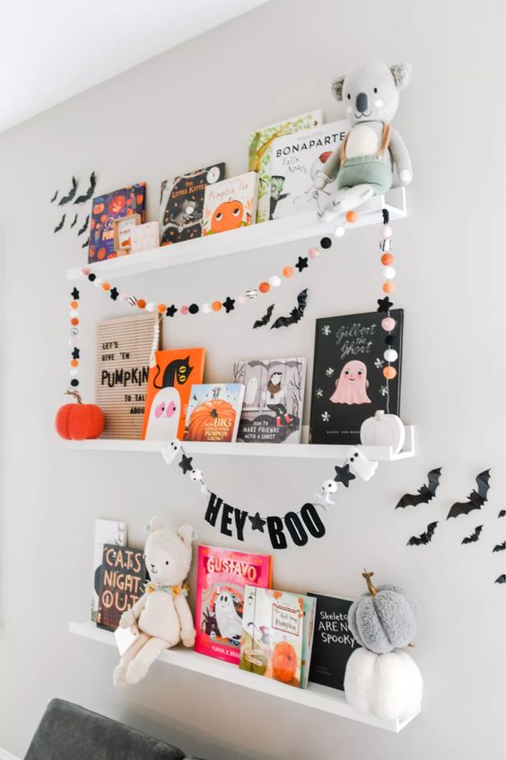 colorful felt pompoms and stars, a banner with stars, ghosts and letters are amazing to style your space for Halloween