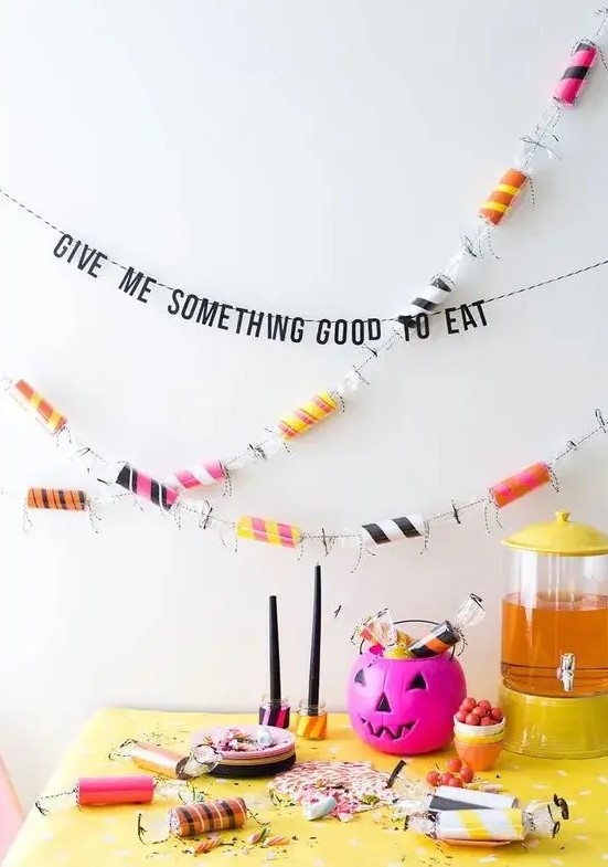 colorize your Halloween party with a colorful toilet paper roll and bright pumpkins, add banners and candy garlands
